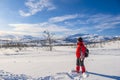 Woman in red sports jacket savors snow and breathtaking Norwegian landscape