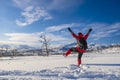 Woman in red sports jacket savors snow and breathtaking Norwegian landscape