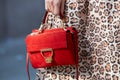 Woman with red suede Coccinelle bag before Giorgio Armani fashion show, Milan Fashion Week street style on Royalty Free Stock Photo