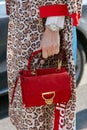 Woman with red suede Coccinelle bag and Rolex watch before Giorgio Armani fashion show, Milan Fashion Week