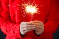 Woman in red sweater holding burning sparklers, closeup Royalty Free Stock Photo