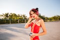 Woman in red swimsuit listening to music from vintage player