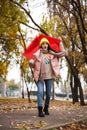 Woman with red umbrella caught in gust of wind outdoors