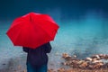 Woman with red umbrella contemplates on rain Royalty Free Stock Photo