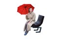 A woman with a red umbrella sits on a city street bench, isolated on a Royalty Free Stock Photo