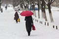 Woman with a red umbrella is on the street in the snow storm Royalty Free Stock Photo