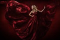 Woman in red waving dress dancing with flying fabric Royalty Free Stock Photo