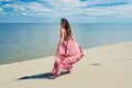 Woman in red waving dress with flying fabric runs on background of dunes. Royalty Free Stock Photo