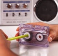 Woman reeling compact audio cassette with a pen