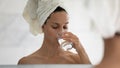 Woman reflected in mirror while drinking still water