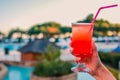 Woman with refreshing cocktail near swimming pool outdoors, closeup. Space for text Royalty Free Stock Photo