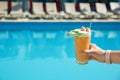 Woman with refreshing cocktail near swimming pool outdoors, closeup Royalty Free Stock Photo