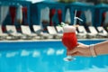 Woman with refreshing cocktail near swimming pool outdoors. Space for text Royalty Free Stock Photo