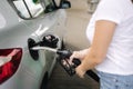 Woman is refueling at gas station. Female hand filling benzine gasoline fuel in car. Petrol prices concept Royalty Free Stock Photo