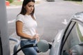 Woman is refueling at gas station. Female hand filling benzine gasoline fuel in car. Petrol prices concept Royalty Free Stock Photo