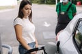 Woman is refueling at gas station. Female hand filling benzine gasoline fuel in car. Petrol prices concept. Gas station Royalty Free Stock Photo