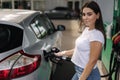 Woman is refueling at gas station. Female hand filling benzine gasoline fuel in car using a fuel nozzle. Petrol prices