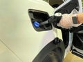 Woman refueling at gas station filling the fuel tank in a white car