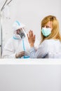 Woman refuses medical worker in PPE to perform nasal swab COVID-19 test in hospital lab Royalty Free Stock Photo
