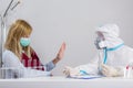 Woman refuses medical worker in PPE to perform nasal swab COVID-19 test in hospital lab Royalty Free Stock Photo