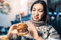 Woman refuses to eat a fat and spicy burger in a restaurant. Perhaps she is a vegetarian or simply stay healthy or