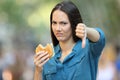 Woman refusing a burger with thumbs down