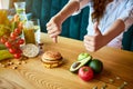 Woman is refusing to eat unhealthy hamburger. Cheap junk food vs healthy diet