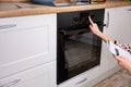 Woman regulating cooking mode on oven panel