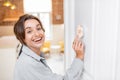 Woman regulating heating temperature with a smart thermostat Royalty Free Stock Photo