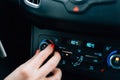 Woman regulating temperature on car air condition. Royalty Free Stock Photo