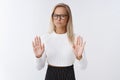 Woman rejects disrespectful offer. Upset and displeased gloomy blond female businesswoman in glasses and cropped sweater