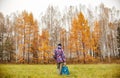 Woman rejoices at the arrival of autumn. Girl in a field near the yellow autumn forest, autumn came, the emotion of joy Royalty Free Stock Photo
