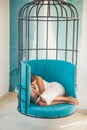 Woman relax in cage chair at home. daytime sleep of tired girl in cage chair. sweet and comfort dream, morning. modern