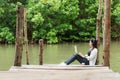 Woman relax and chill while listening music with headphone and laptop in the outdoor education nature green park, girl happy.