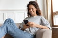 Woman relaxing at home with smartphone spend time on internet Royalty Free Stock Photo