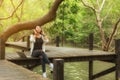 Woman relax and reading a book while listening music with headphone and laptop in the nature green park, girl happy.