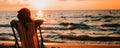 A woman relaxes in a chair on the sandy beach, enjoying the ocean view and feeling the gentle breeze Royalty Free Stock Photo