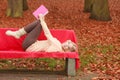 Woman relaxing in autumn fall park reading book. Royalty Free Stock Photo