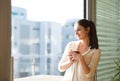 Woman relaxing on balcony holding cup of coffee or tea Royalty Free Stock Photo