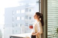 Woman relaxing on balcony holding cup of coffee or tea Royalty Free Stock Photo