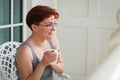 Woman relaxing on balcony holding cup of coffee or tea Royalty Free Stock Photo