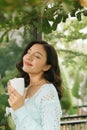 Woman relaxing on balcony holding cup of coffee or tea Royalty Free Stock Photo