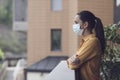 Woman relaxing on the balcony and wearing a face mask Royalty Free Stock Photo