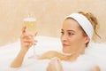Woman Relaxing In Bath With Glass Of Champagne