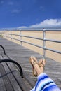 Woman relaxing on beach, feet in sandals close up. Royalty Free Stock Photo