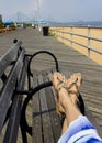 Woman relaxing on beach, feet in sandals close up. Royalty Free Stock Photo