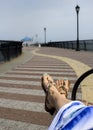 Woman relaxing on beach, feet in sandals close up. Royalty Free Stock Photo