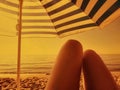 Woman relaxing on a beach with umbrella at romantic sunset sand sepia vintage retro coloring Royalty Free Stock Photo