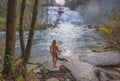 Woman relaxing by beautiful waterfall. Royalty Free Stock Photo
