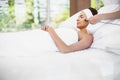 Woman relaxing on bed while receiving facial massage Royalty Free Stock Photo